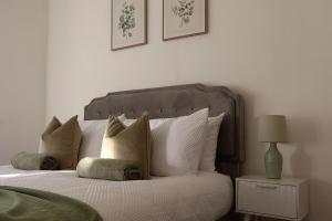 een slaapkamer met een bed met kussens en een lamp bij Henderson Home Sleeps 3 with Allocated Parking in Pallion