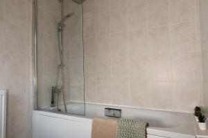 a bathroom with a tub with a glass shower at Henderson Home Sleeps 3 with Allocated Parking in Pallion