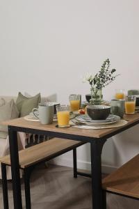 a wooden table with food and glasses of orange juice at Henderson Home Sleeps 3 with Allocated Parking in Pallion