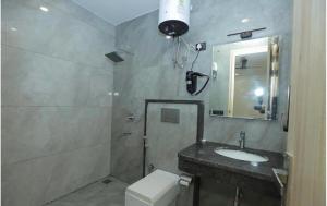 Un baño con lavabo, inodoro y espejo. en Hotel Verano, en Nueva Delhi 16 fotos más