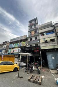 a yellow car parked in front of a building at 98 Inn BilikXpert at Chow Kit in Kuala Lumpur