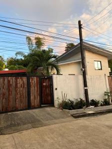 ein Haus mit einem Holztor und einem Zaun in der Unterkunft Northern Belle guesthouse in San Fernando