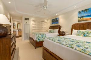 ein Schlafzimmer mit zwei Betten und einem Deckenventilator in der Unterkunft Kaanapali Alii 2 Bedroom Oceanfront in Hyatt Regency Maui Hotel Heliport