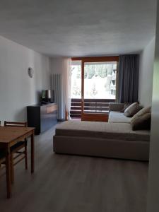a living room with a bed and a window at Appartamento Valfurva 15 in Santa Caterina Valfurva