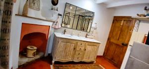 baño con lavabo y chimenea en Le Ptit Cottage, en Nyons