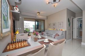 a dining room and living room with a table and chairs at Home Batel in Curitiba