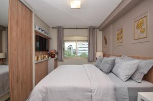 a bedroom with a white bed and a window at Home Batel in Curitiba +34 photos