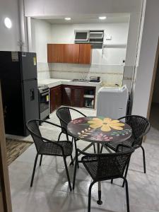 a kitchen with a table and chairs and a kitchen with a refrigerator at Apartamento céntrico amplio y seguro in Cali