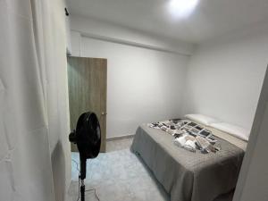 a bedroom with a bed in a room with a camera at Apartamento céntrico amplio y seguro in Cali