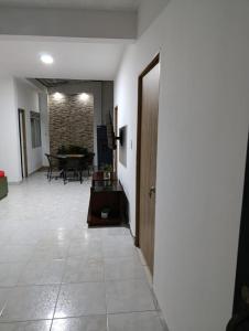 a hallway with a room with a table and a door at Apartamento céntrico amplio y seguro in Cali +9 photos