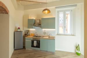 a kitchen with blue cabinets and a sink and a refrigerator at La Casina del Popi in Arezzo