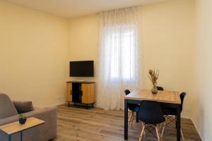 a living room with a couch and a table and a television at La Casina del Popi in Arezzo