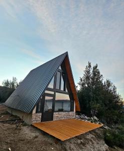 una casa pequeña con techo a dos aguas y una ventana grande en Complejo Bahia de los Sueños, Cabaña Maitenes, en Aluminé