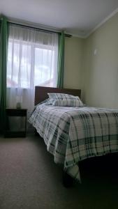 a bedroom with a bed and a window at Refugio tranquilo en Bosquemar in Puerto Montt +6 photos
