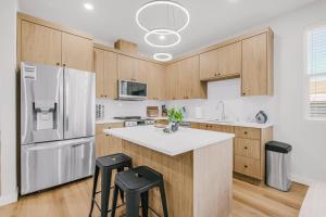 une cuisine avec des armoires en bois et un réfrigérateur blanc dans l'établissement New Spacious Evergreen Home For Family Getaways, à Gresham