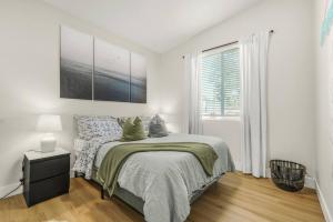 a white bedroom with a bed and a window at Amazing and Comfy Home With A Fire Place and Big Backyard in Orchards