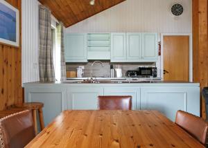 a kitchen with a wooden table with chairs and a kitchen counter at Lochearnhead Loch Side in Lochearnhead