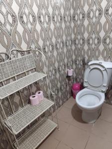 a bathroom with a toilet and a patterned wall at maison rio la rufisquoise in Saly Portudal