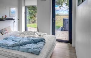 uma cama não feita num quarto com uma porta aberta em Nice Home In Haderslev With Sauna em Årøsund mais 10 fotografias