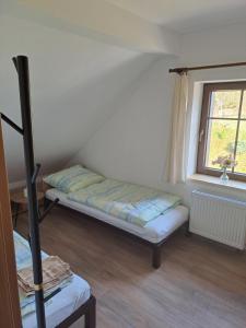 a small room with a bed and a window at Bike & Enduro Penzion Petříkovice in Chvaleč
