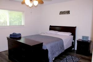 ein Schlafzimmer mit einem Bett, einer Kommode und einer Wanduhr. in der Unterkunft Walk to beach Galveston Getaway in Galveston