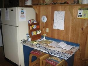 eine Küche mit einem Tisch, einem Kühlschrank und einer Theke in der Unterkunft Half Moon Guest House in Clearwater