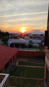 ein Blick auf einen Sonnenuntergang von einem Gebäude aus in der Unterkunft Xangrilá, um paraíso perto da praia in Xangri-lá