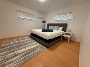 a bedroom with a bed and a rug and two windows at Golden Acres in Calming Caldwell in Caldwell