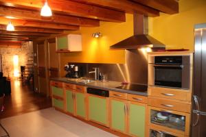 a kitchen with yellow walls and wooden cabinets at Coeur de Vogüé in Vogüé