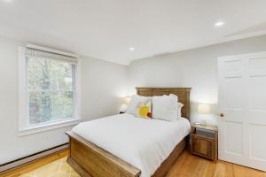 Una habitación blanca con una cama y una ventana en Mitchell Manor MV, en Vineyard Haven