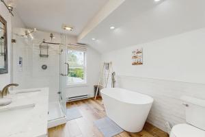 Un baño blanco con bañera y ducha. en Mitchell Manor MV, en Vineyard Haven 19 fotos más