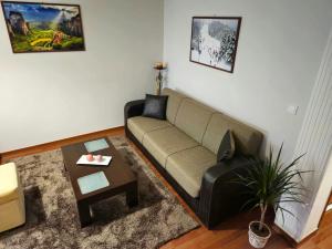 Una sala de estar con un sofá y una mesa de café. en Calliope's Home, en Tríkala