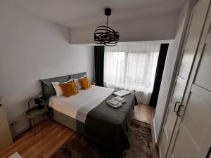 a small bedroom with a bed and a window at Newton Flat Apartment in Văleni