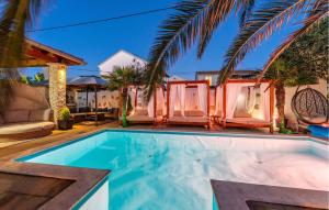 a swimming pool in front of a house at Amazing Apartment In Sukosan in Sukošan