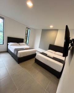 a hotel room with two beds and a tv at Dalusa House in Tena +3 photos