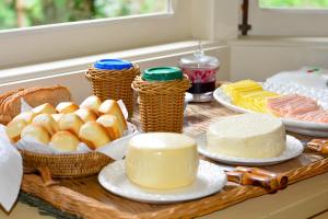 a table with different types of bread and cakes at Villa Coração Guesthouse by Concavus in Monte Verde +15 photos