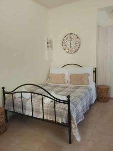 a bedroom with a bed with a clock on the wall at Afroessa Apartment Ithaca in Vathi, Ithaka