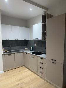 a kitchen with white cabinets and a sink at Class Apartments in Tirana