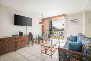 een woonkamer met een bank en een tafel met stoelen bij Kona Islander in Kailua-Kona