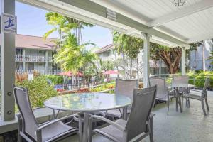 een patio met een glazen tafel en stoelen bij Kona Islander in Kailua-Kona +9 foto's