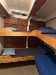 a room with three bunk beds in a boat at The Vega 1909 - Historic Wooden Ship in Amsterdam