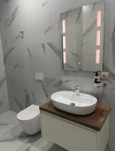 a white bathroom with a sink and a toilet at Class Apartments in Tirana