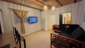 ein Wohnzimmer mit einem Sofa und einem Fernseher an der Wand in der Unterkunft La Mesa - Manzanares in La Mesa + 3 Fotos