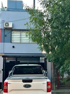 a white truck parked in front of a garage at Orillas del Sol Triplex in Chascomús