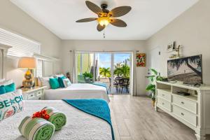 ein Schlafzimmer mit zwei Betten und einem Deckenventilator in der Unterkunft The No Problem at Cottages in Sand Bluff