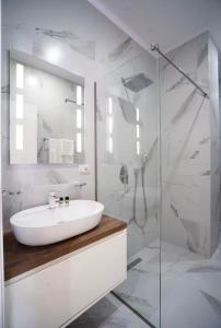 a white bathroom with a sink and a shower at Class Apartments in Tirana +23 photos
