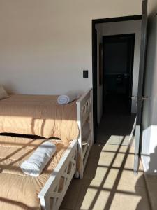 a bedroom with two beds and a door to a room at Orillas del Sol Triplex in Chascomús