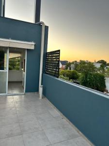 a building with a blue wall and a balcony at Orillas del Sol Triplex in Chascomús