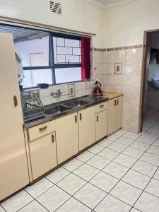a kitchen with a sink and a window at Black chilli accommodation in Brackenfell
