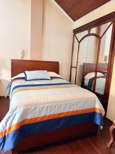 a bedroom with a bed and a mirror at House Loft Loja in Loja +3 photos